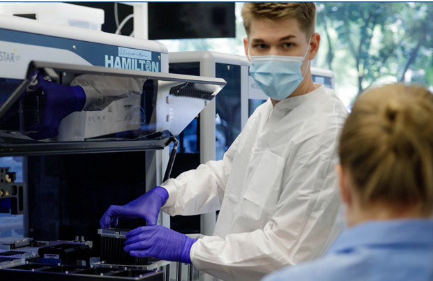 student in lab wearing gloves and mask