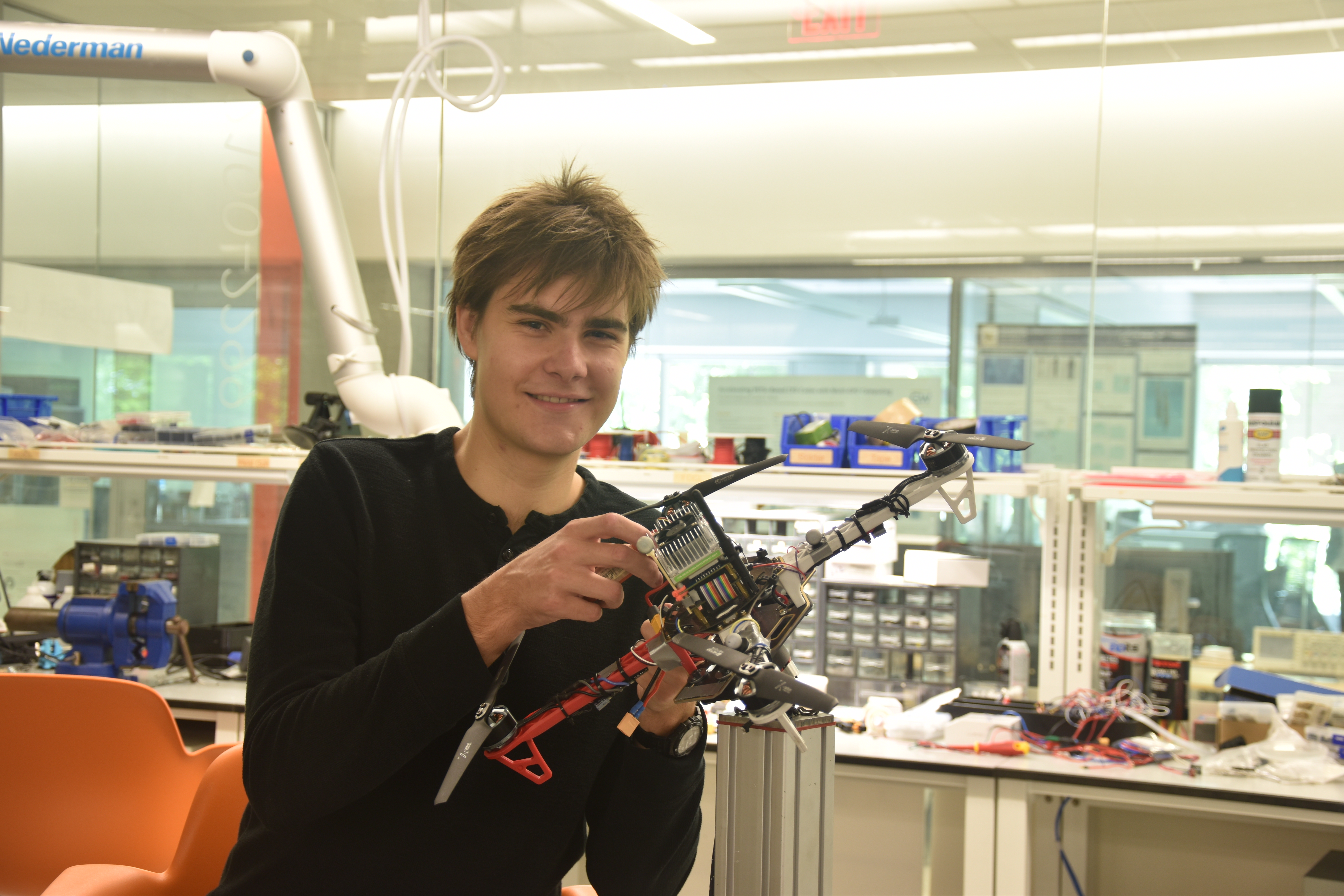 Karl Simon holding a drone in the Science & Engineering Hall's flight test facility