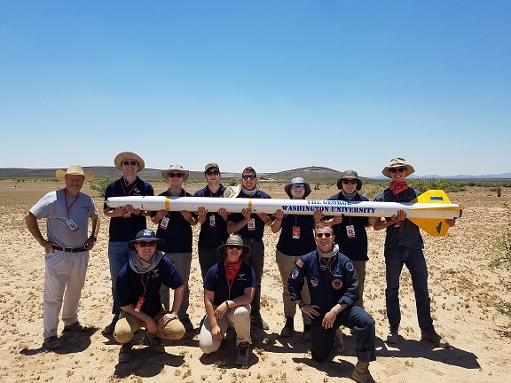 Rocket Team holding their rocket in the New Mexico desert